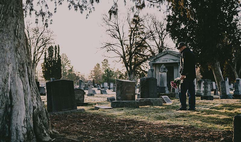 Man standing in cemetery.